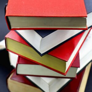 A diverse stack of hardcover books with red and black covers, perfect for education-themed projects.