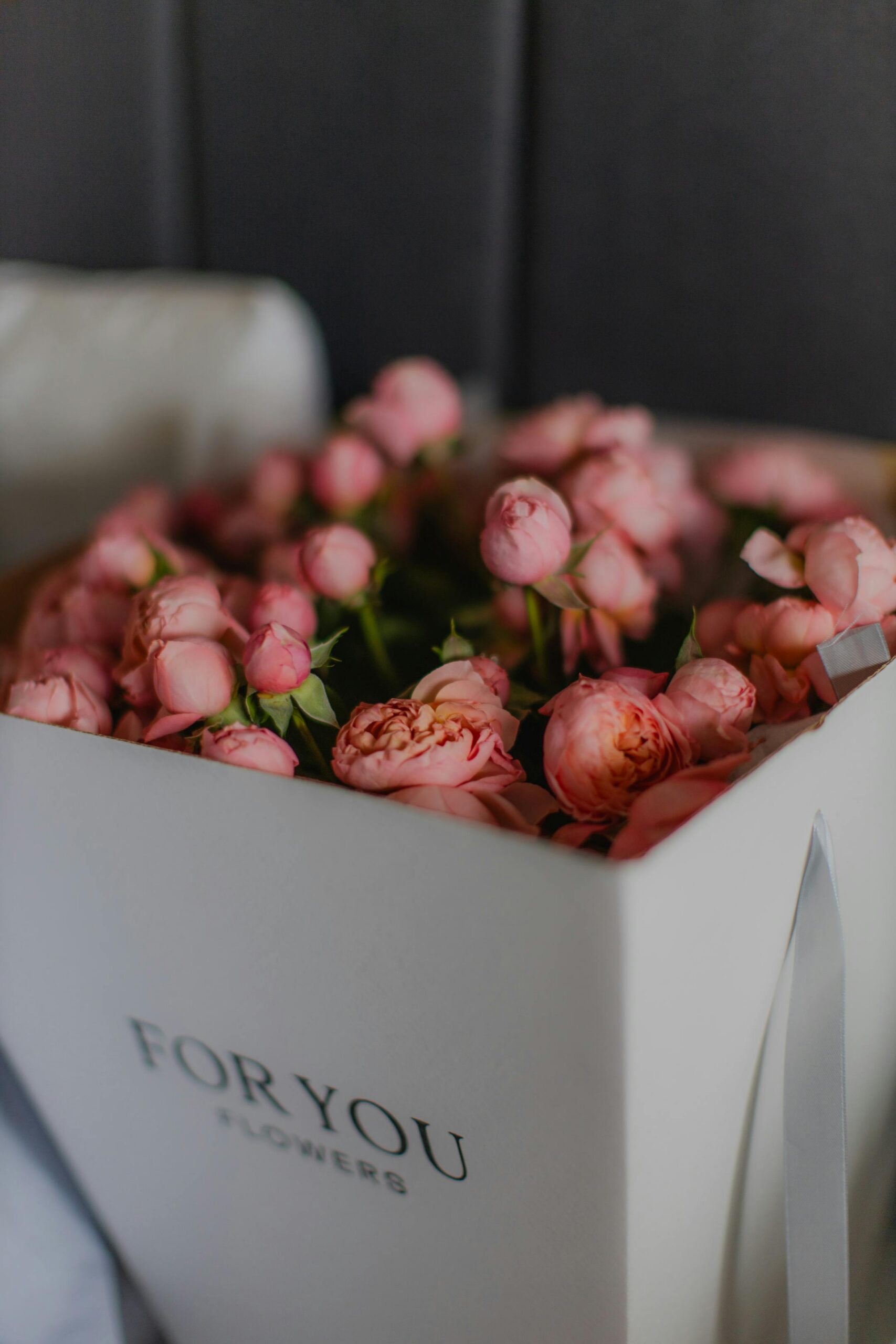 Beautiful pink peonies arranged in a chic gift box, perfect for special occasions.